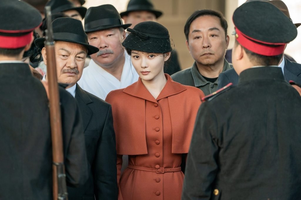 Kim You-jung as Lee Ga-kyung in a red coat surrounded by uniformed officers at the station