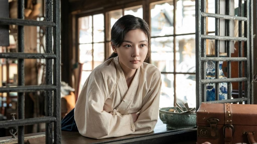 Kim You-jung as Lee Ga-kyung leaning across a shop counter in 100 Days of Deception