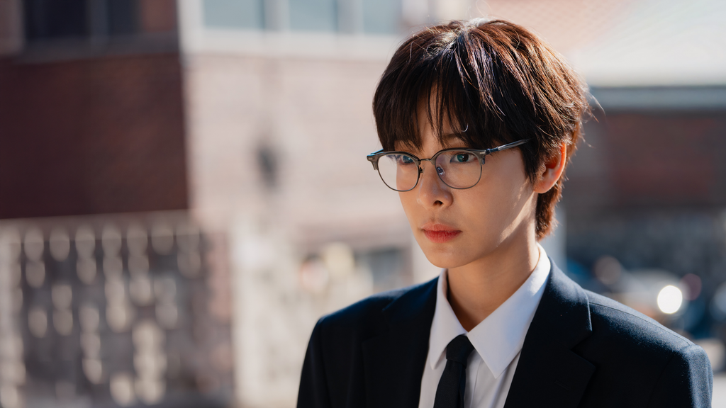 Seol In-ah as Kang Jae-hee wearing glasses and a dark suit