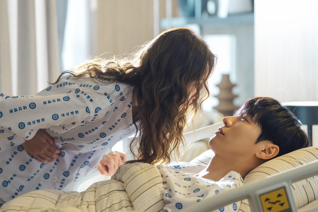 a Bo-bae leans over Baek Ho-rang in a hospital bed.