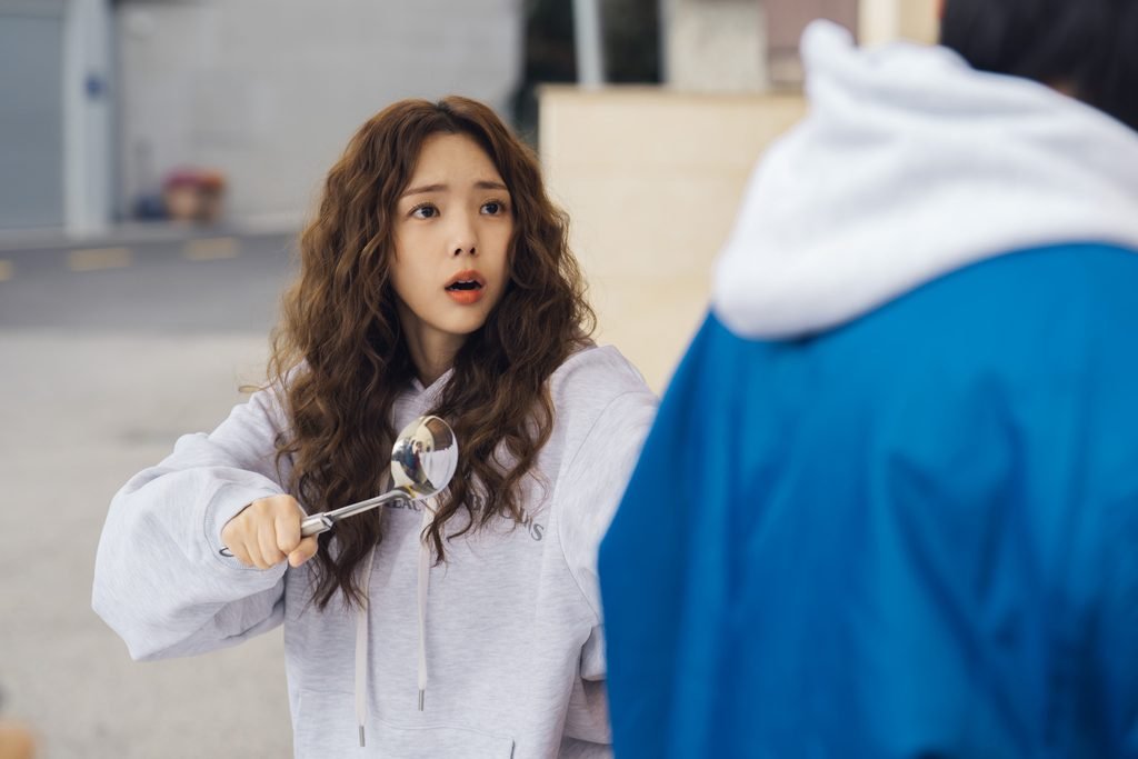 Chae Soo-bin as Na Bo-bae holding kitchen utensils with a surprised expression.